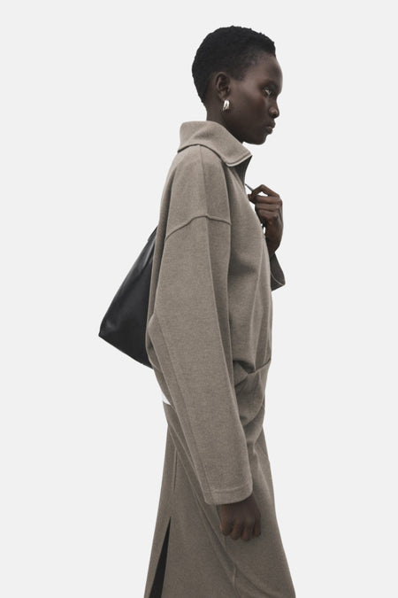 Bruine MANGO-sweatshirt, losse pasvorm, klassieke kraag, gedragen met een wit T-shirt en een bijpassende rok.
