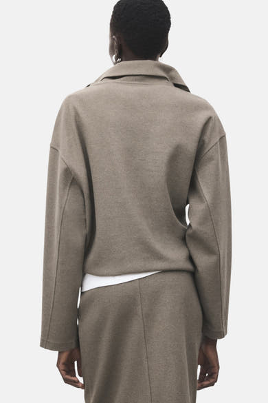 Sweat-shirt marron de MANGO, coupe ample, col classique, porté avec un t-shirt blanc et une jupe assortie.