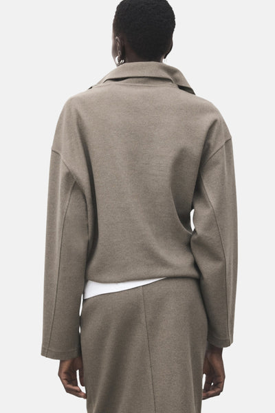 Sweat-shirt marron de MANGO, coupe ample, col classique, porté avec un t-shirt blanc et une jupe assortie.
