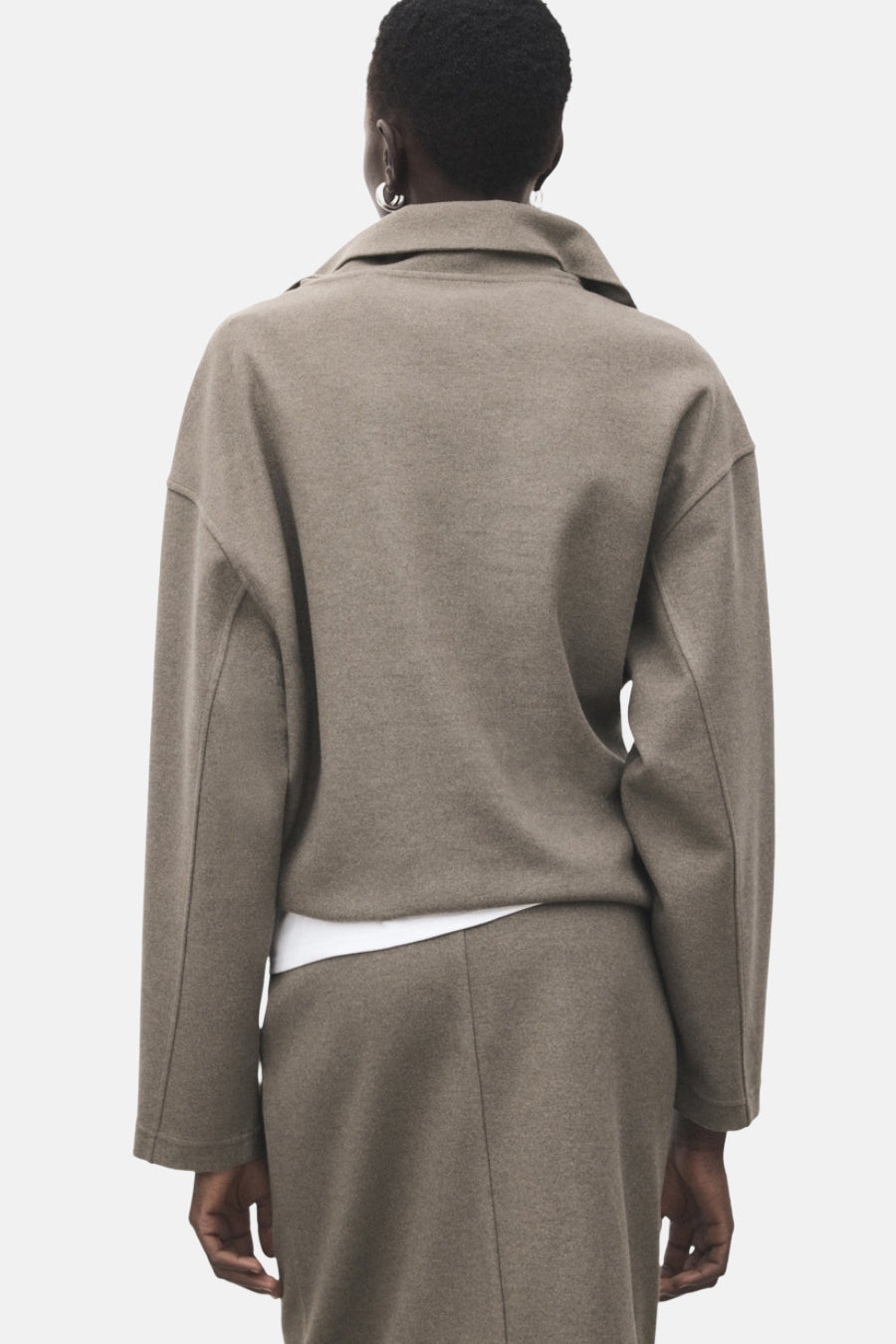 Sweat-shirt marron de MANGO, coupe ample, col classique, porté avec un t-shirt blanc et une jupe assortie.