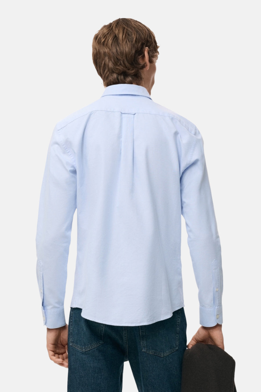 Chemise bleu clair à manches longues de MANGO, vue de dos sur un mannequin portant un jean.
