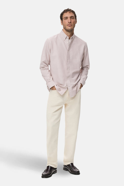 Chemise à manches longues rose de MANGO, portée avec un pantalon clair et des mocassins en cuir.