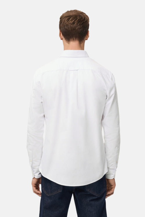 Chemise blanche à manches longues de MANGO, vue de dos avec boutonnière et détail de plis.