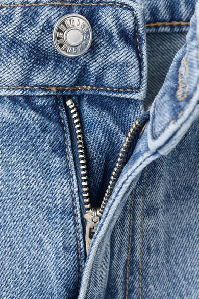 Jean droit en denim bleu clair de MANGO, avec fermeture éclair et bouton en métal.