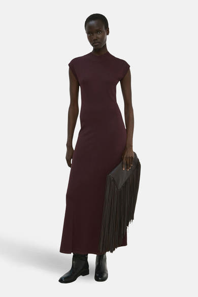 Robe à manches courtes marron de MANGO, portée avec une pochette à franges et des bottines noires.
