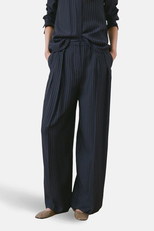 Pantalon bleu à rayures, par MANGO, avec plis et jambes larges.