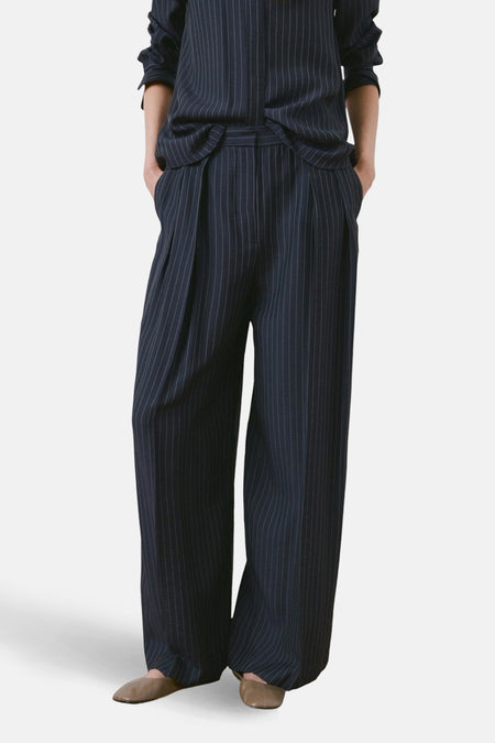 Pantalon bleu à rayures, par MANGO, avec plis et jambes larges.