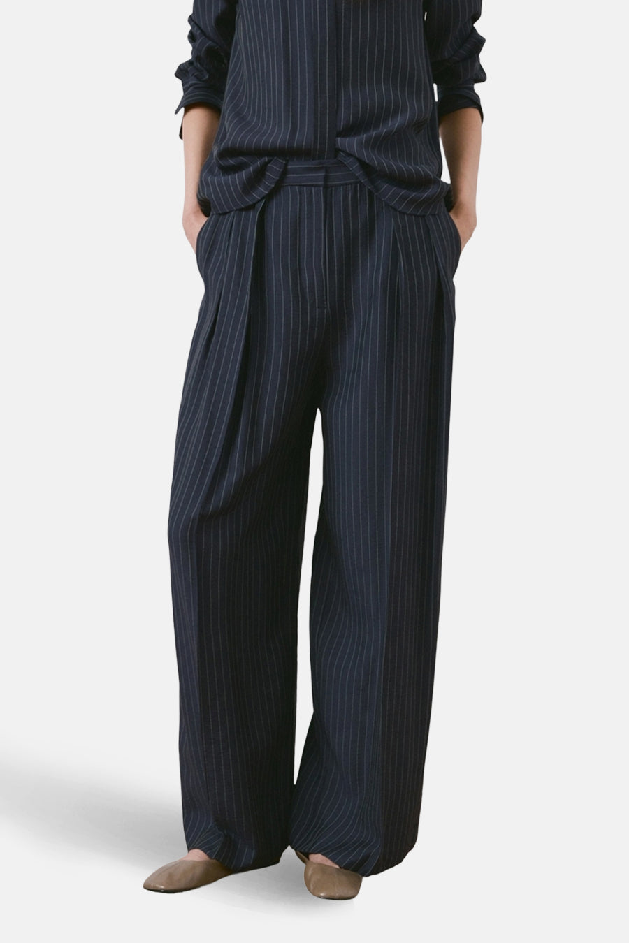Blauwe gestreepte broek van MANGO, losse pasvorm en wijde pijpen, met zakken, van achteren getoond.