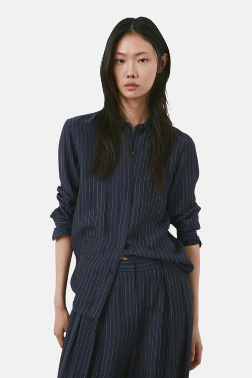 Pantalon bleu rayé de MANGO, assorti avec une chemise rayée et souple.