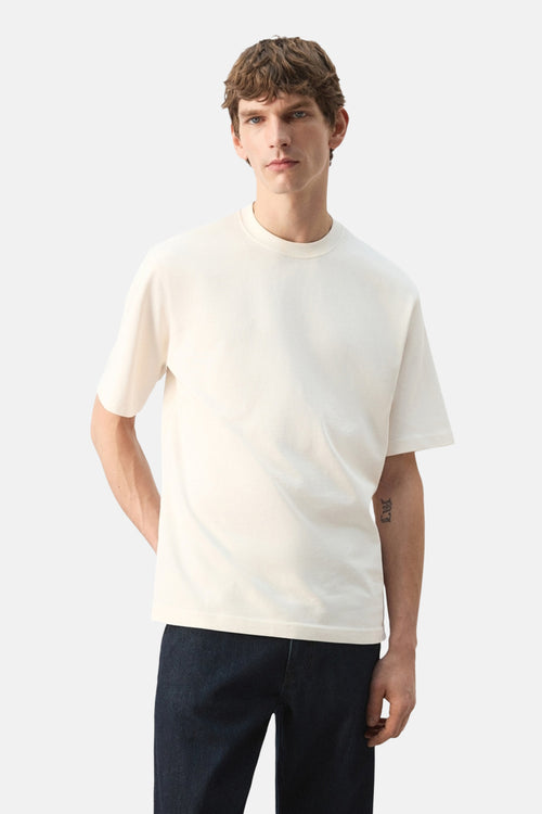 T-shirt écru à manches courtes de MANGO, porté avec un jean en denim foncé.