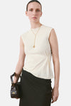 Beige mouwloze top van MANGO, gedragen met een zwarte rok met hoge taille.