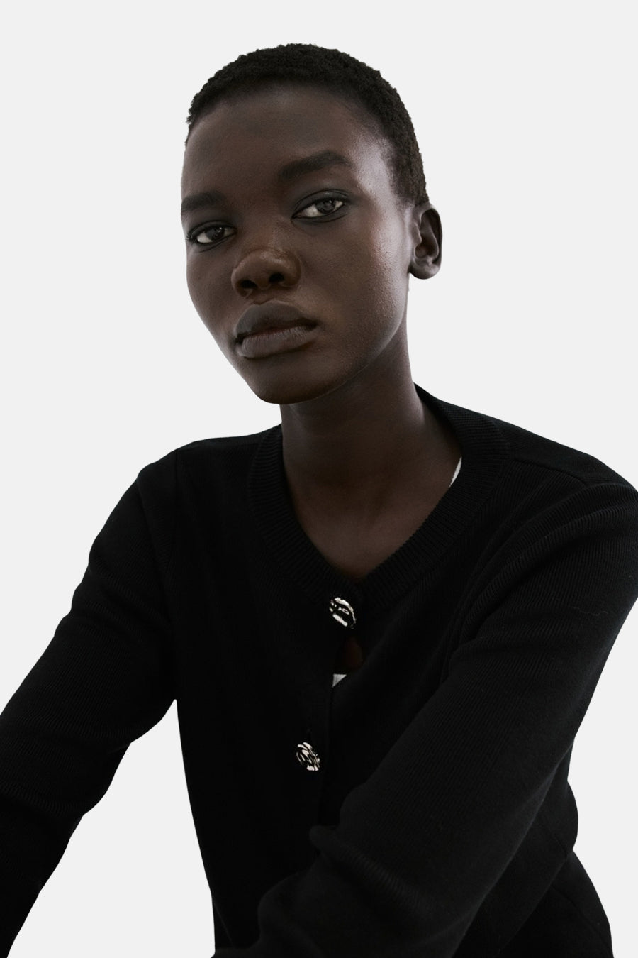 Gilet noir de MANGO, avec boutons décoratifs argentés et encolure arrondie.