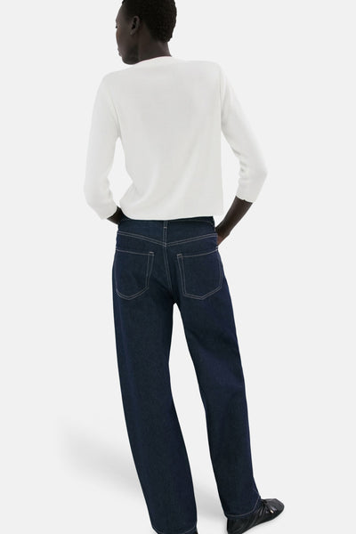 Gilet blanc de MANGO, porté avec un jean bleu foncé ample, vue de dos.
