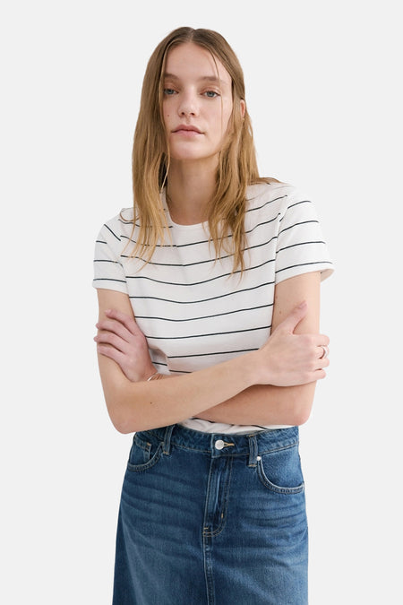 Wit T-shirt met zwarte strepen van MANGO, gedragen met een blauwe spijkerrok, van achteren gezien.