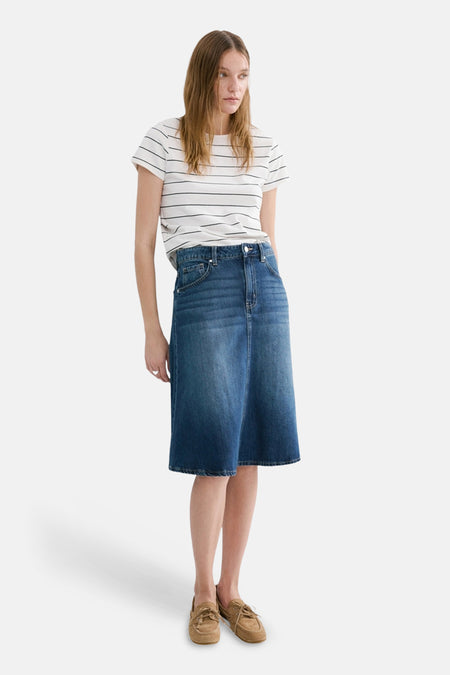 Wit gestreept T-shirt van MANGO, gedragen met een blauwe spijkerrok en bruine bootschoenen.
