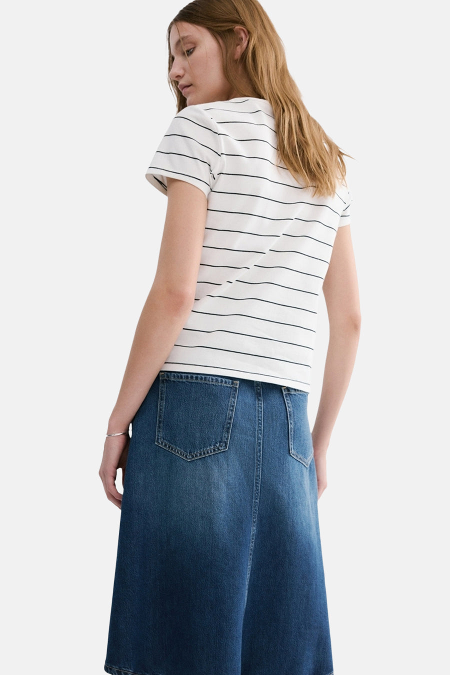 T-shirt blanc à rayures noires de MANGO, porté avec une jupe en jean bleu, vue de dos.
