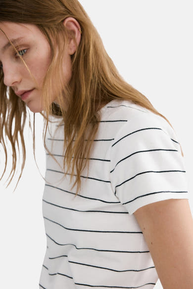 Wit T-shirt met zwarte strepen van MANGO, gedragen door een model met blond haar.