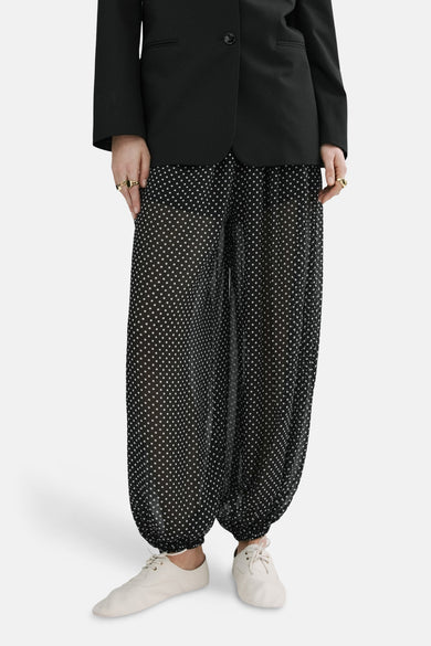 Zwarte broek van MANGO met witte stippen, met een zwart jasje en een witte sjaal.