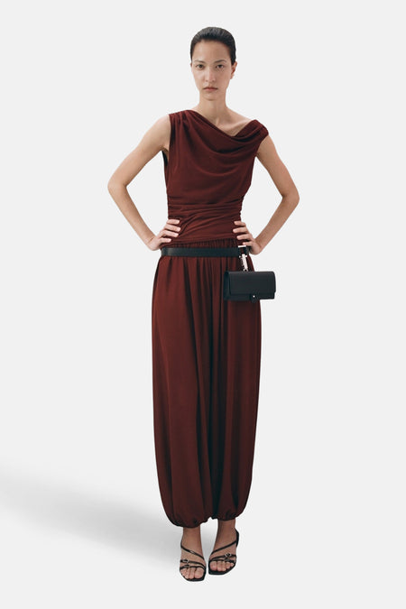 Top sans manches brun de MANGO, drapé autour du cou, porté avec une ceinture noire et un pantalon ample marron.