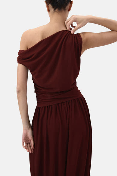 Top sans manches brun de MANGO, avec un détail drapé à l'épaule, porté avec une jupe longue assortie.
