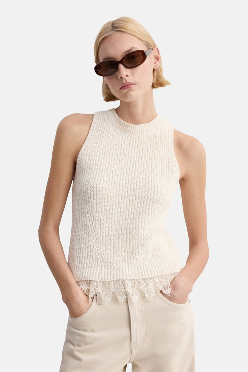 Top écru sans manches de MANGO avec détail en dentelle sur l'ourlet inférieur, porté avec des lunettes de soleil marron.
