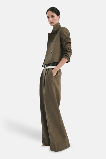 Pantalon kaki, van MANGO, avec une ceinture noire et une coupe ample.