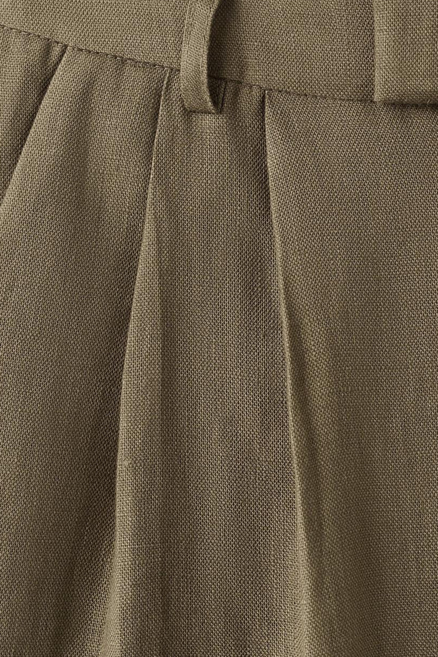 Kaki broek van MANGO met scherpe plooien, een gesp en een zichtbare geweven textuur.