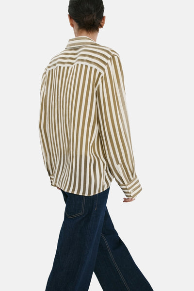 Chemise à manches longues kaki et blanc cassé à rayures de MANGO, vue de dos, portée avec un jean large bleu.