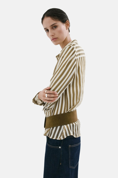 Multikleurige lange blouse van MANGO, wit en kaki gestreept, met geplooide zoom en brede bruine riem, zijdelings gedragen.