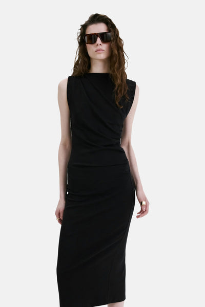 Robe noire de MANGO, sans manches, coupe midi drapée, portée par un mannequin avec des lunettes.