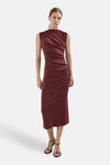 Robe bordeaux de MANGO, sans manches et drapée sur le devant, portée par un mannequin avec des sandales noires à talons.