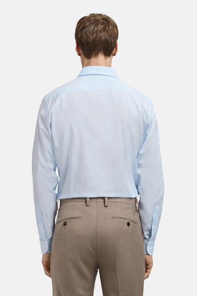 Blauw overhemd met lange mouwen van MANGO, van achteren gezien, gedragen met een beige broek.