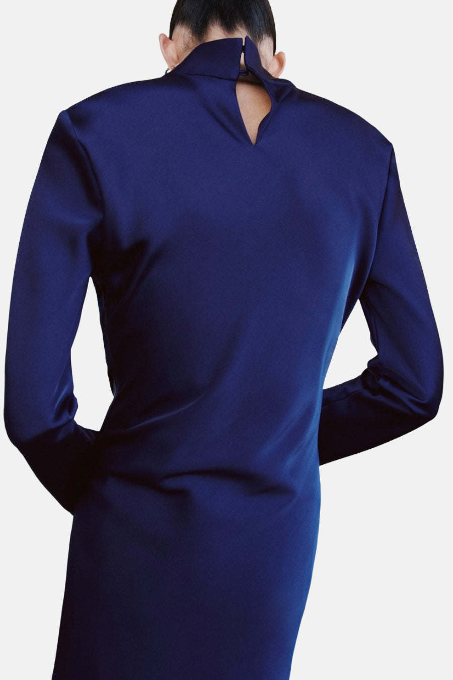 Robe bleu en satin de MANGO, avec une encolure haute et une découpe en goutte d'eau au dos.
