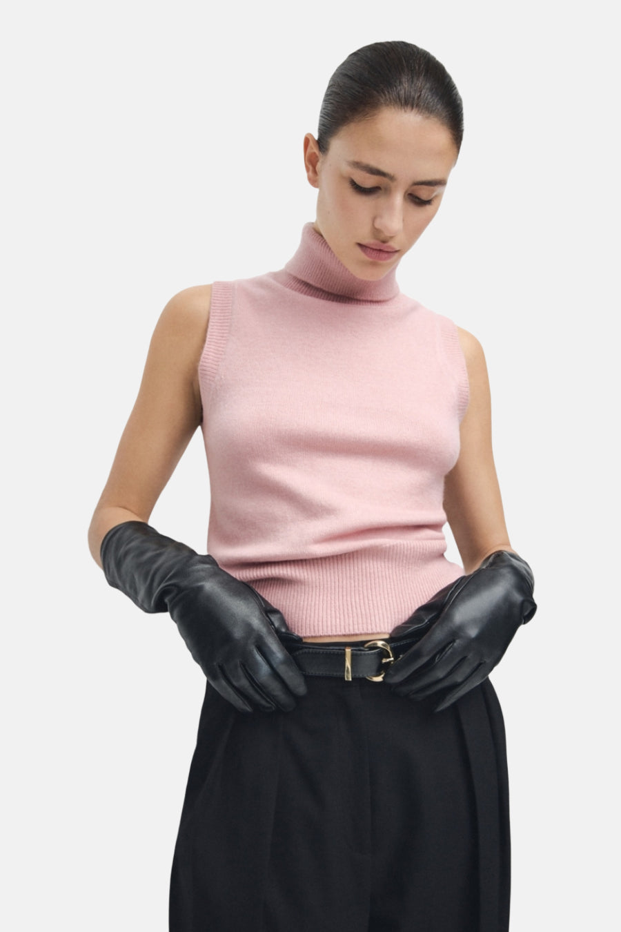 Roze tanktop van MANGO, gedragen met zwarte leren handschoenen en een wijde zwarte broek.