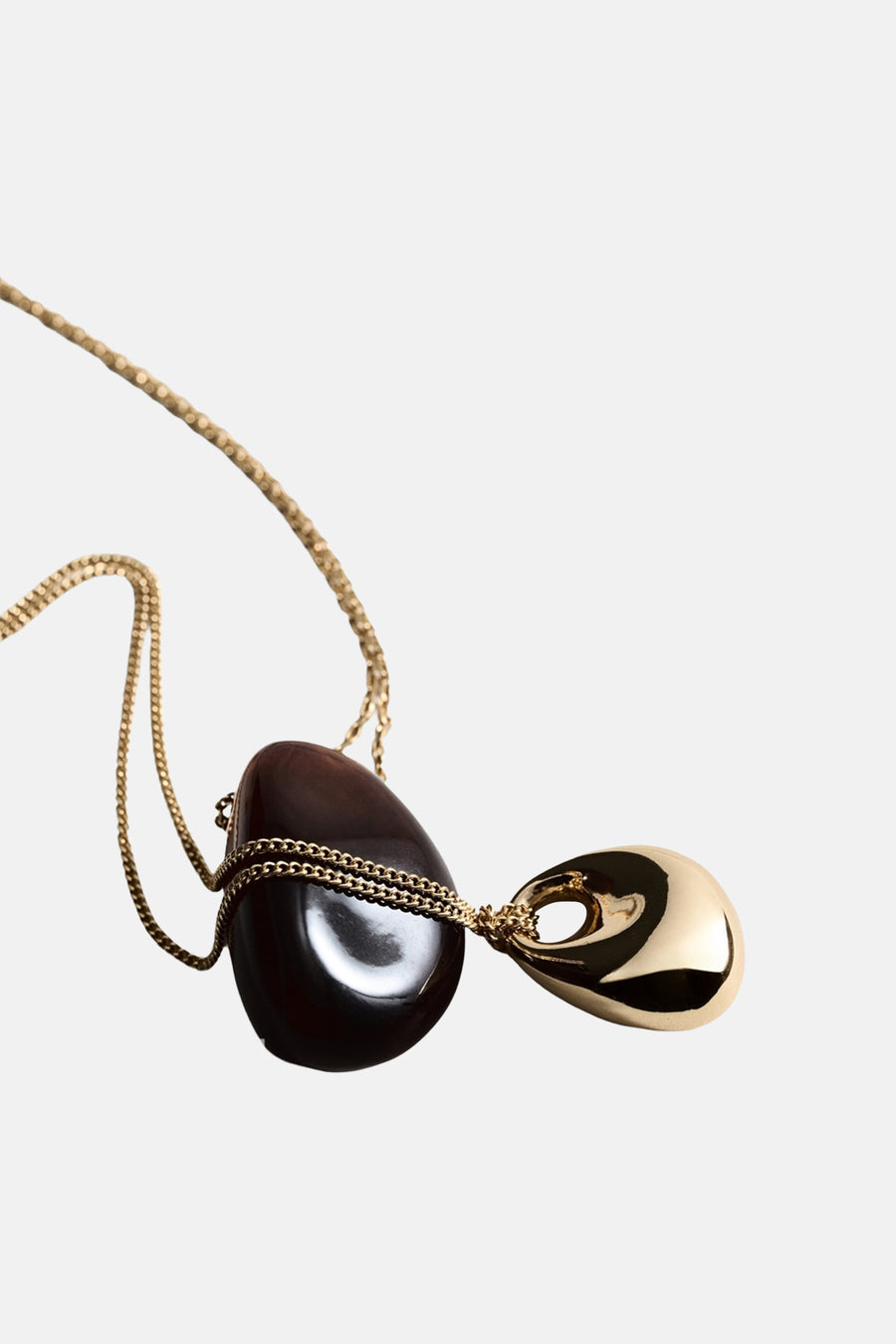Collier court doré, par MANGO, avec deux pendentifs en forme de larme et de pierre foncée.
