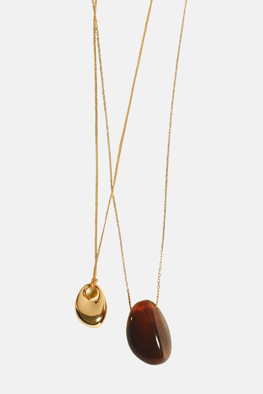 Colliers courts dorés de MANGO avec pendentifs brillants, l'un en or et l'autre en pierre brune.