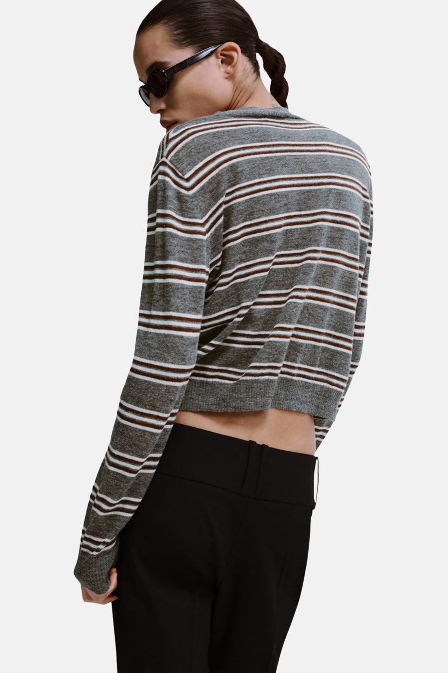 Pull à col rond gris de MANGO, rayé marron et blanc, porté avec un pantalon noir taille haute.