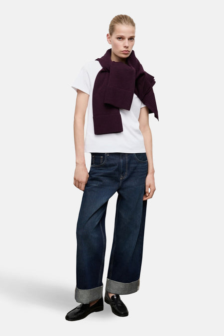 T-shirt à manches courtes blanc de MANGO, porté avec une écharpe prune et un jean large à revers gris.