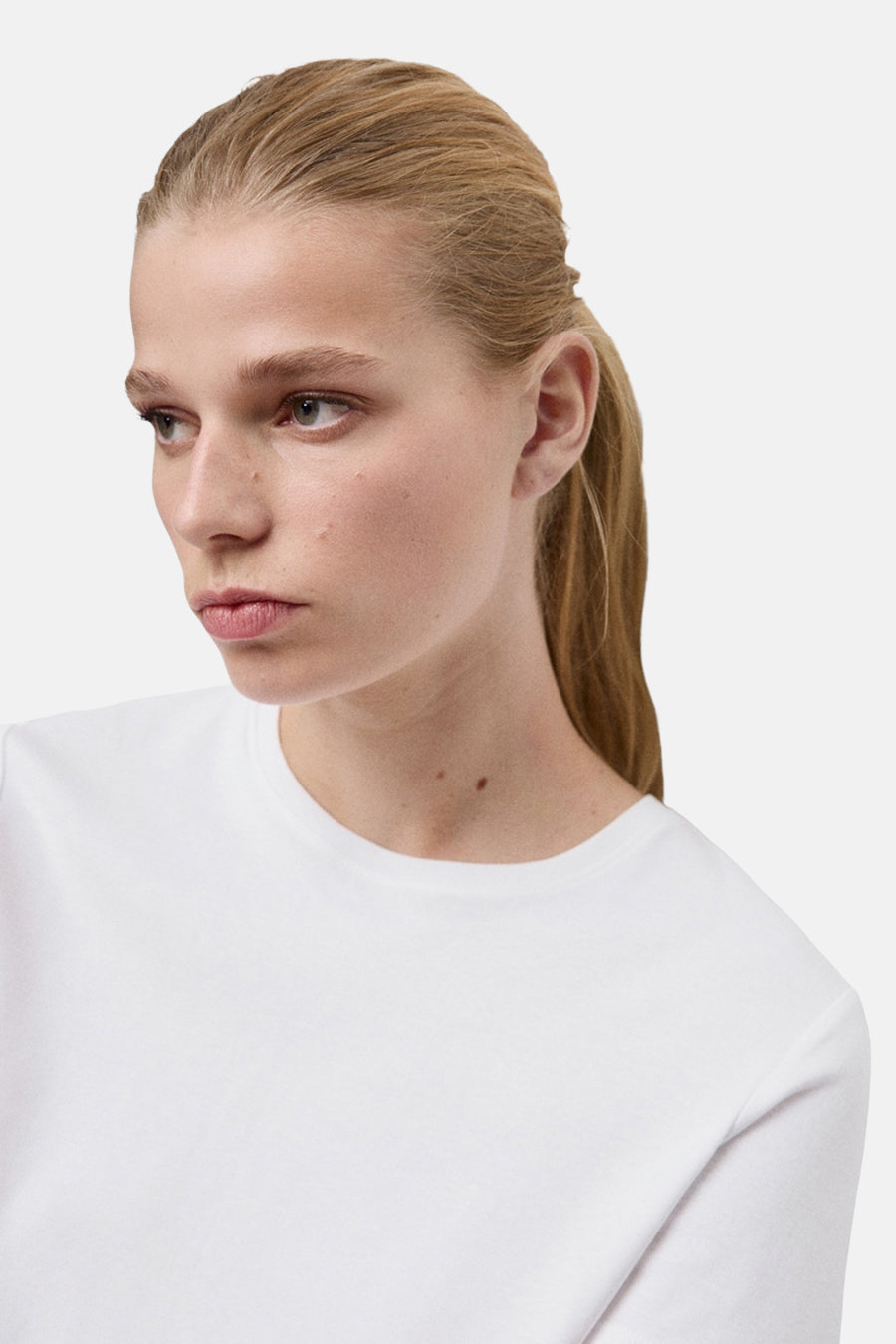 Wit T-shirt met korte mouwen van MANGO, gedragen door een model met een paardenstaart.