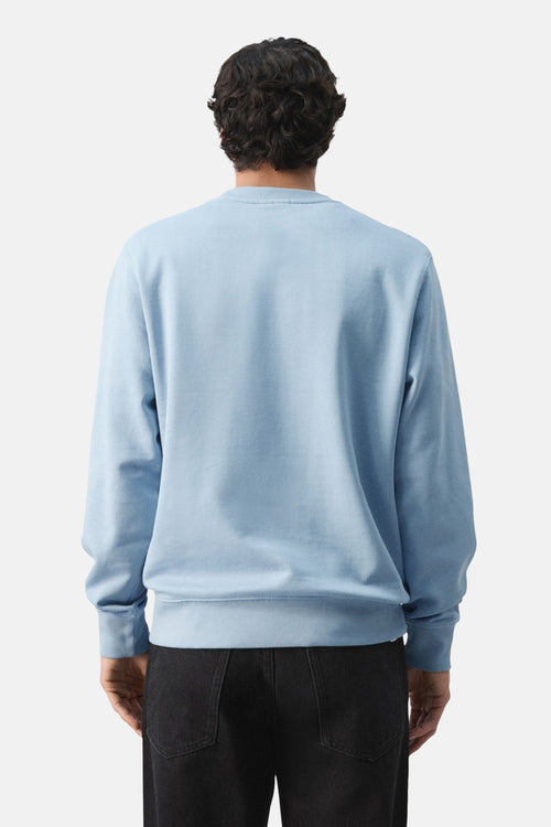 Sweat bleu de MANGO, vu de dos, porté avec un jean noir.