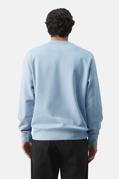 Sweat bleu de MANGO, vu de dos, porté avec un jean noir.
