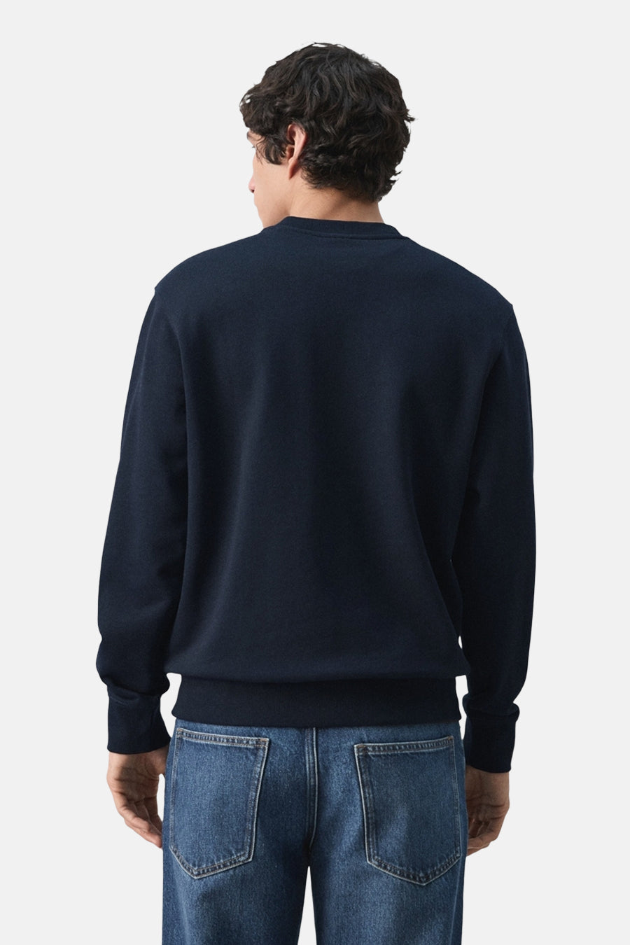 Sweat noir de MANGO, vue de dos, porté avec un jean bleu.

