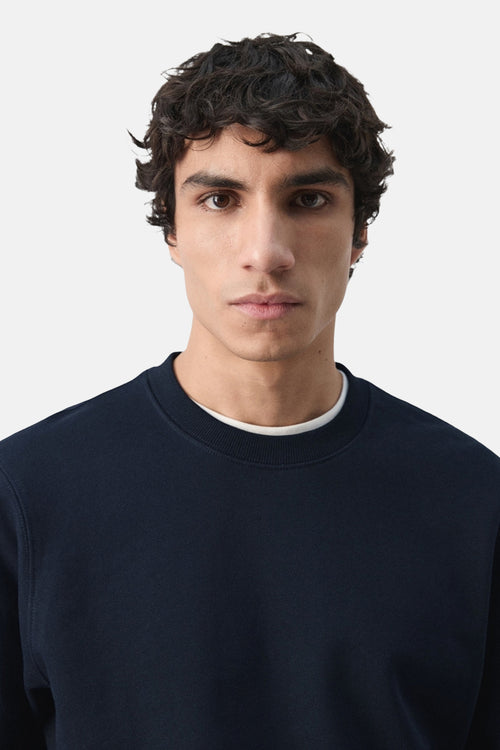 Sweat-shirt noir de MANGO avec un col rond et un t-shirt blanc en dessous.
