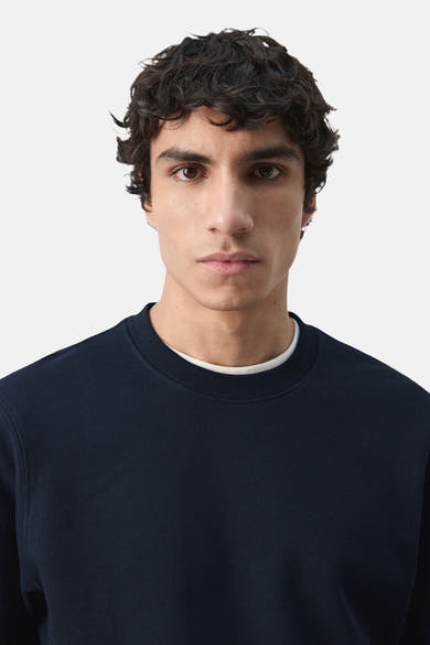 Zwarte MANGO sweatshirt met ronde hals en een wit T-shirt eronder.