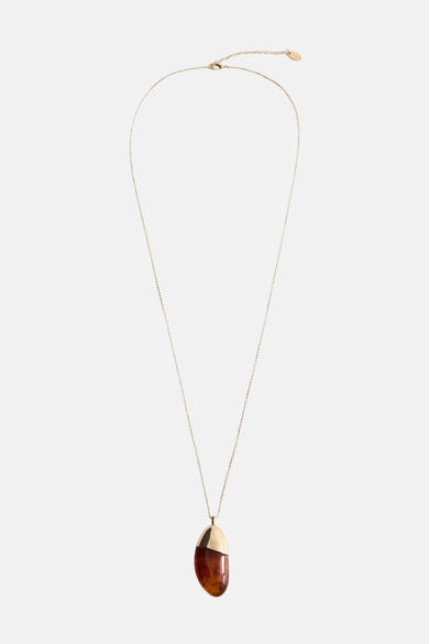 Collier long doré de MANGO, avec pendentif résine marron et détail doré, sur fond uni.