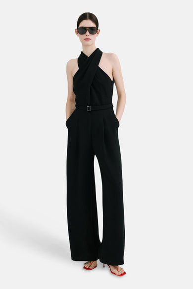 Combinaison noire par MANGO, croisée sur le devant avec une ceinture à boucle et des jambes larges.