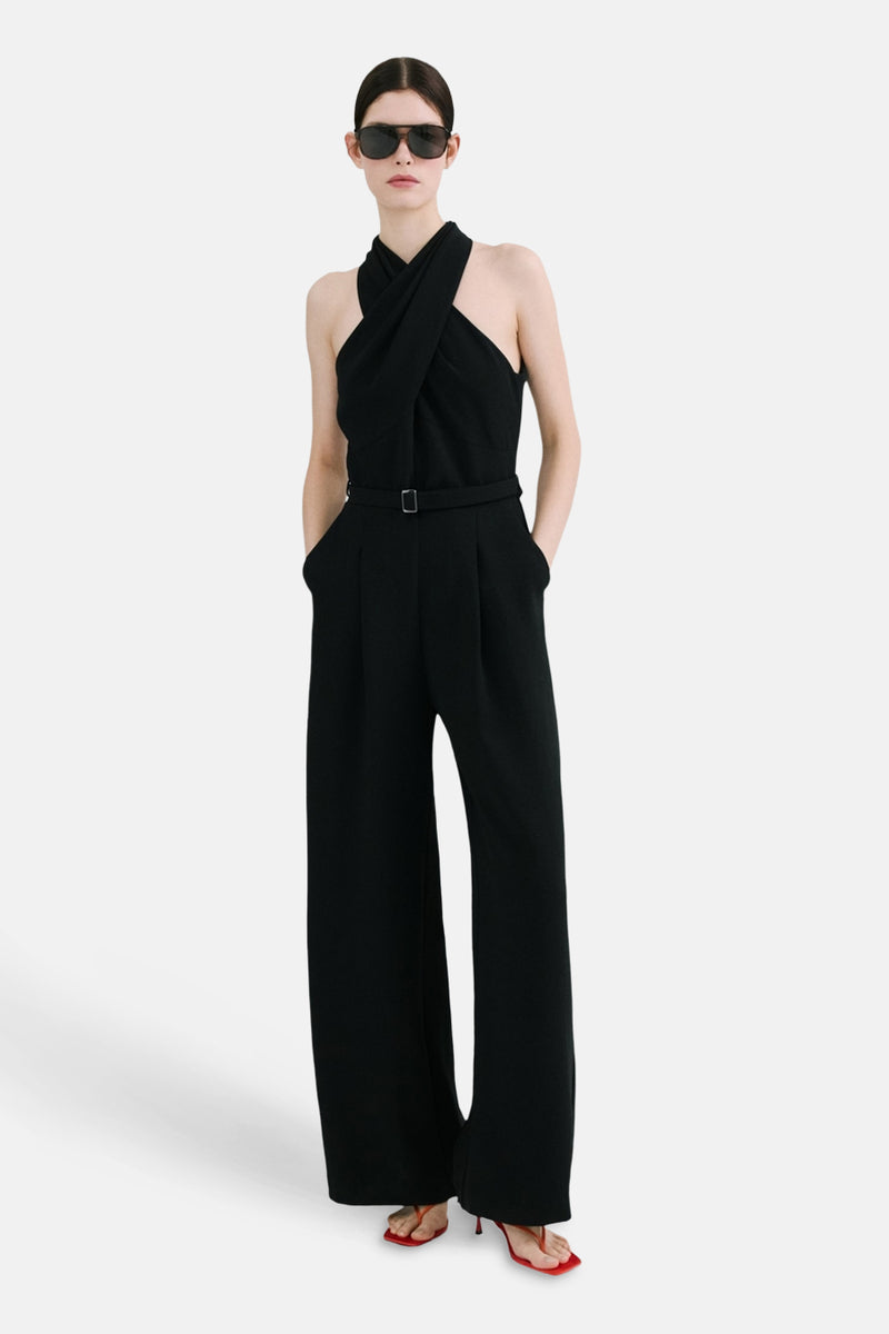 Combinaison noire par MANGO, croisée sur le devant avec une ceinture à boucle et des jambes larges.