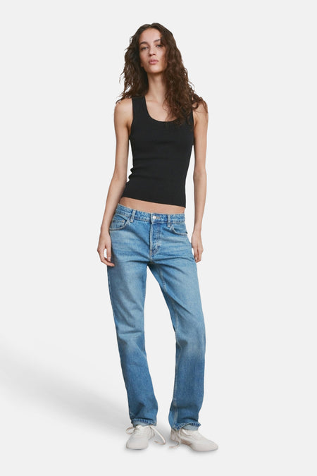 Débardeur noir de MANGO, porté avec un jean bleu et des baskets blanches.
