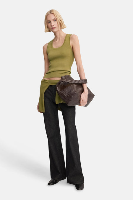 Kaki hemdje van MANGO, gedragen met een donkere uitlopende broek en een gevlochten leren handtas.