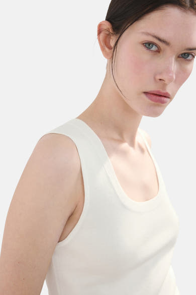 Witte tanktop van MANGO, gedragen door een model met een lichte achtergrond.